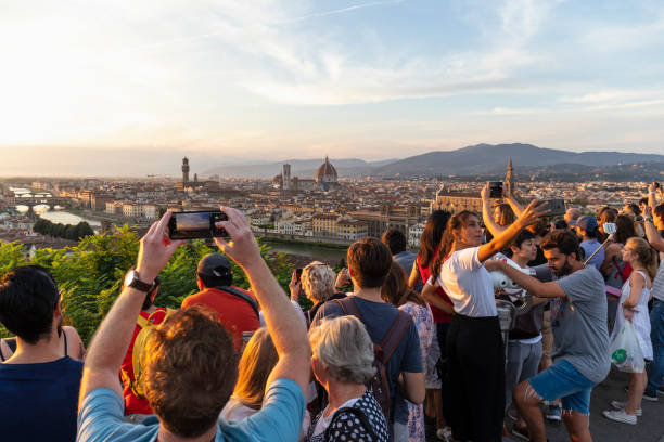Italy, Florence - September 9, 2018: crowd of people taking a selfie and looking sunset on Florence from piazzale Michelangelo