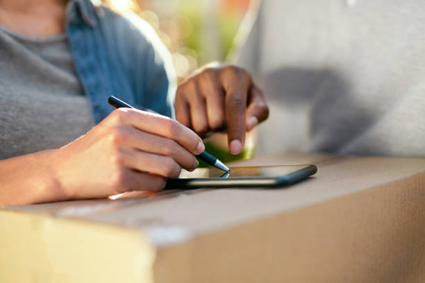 istock Package Delivery. Close Up Hand Signing On Phone On Box 1045266502