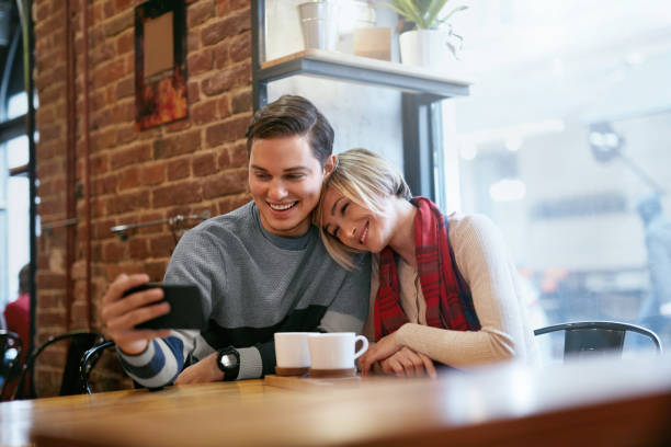 istock Couple Using On Phone In Cafe For Video Calling Or Taking Photos 1045274206