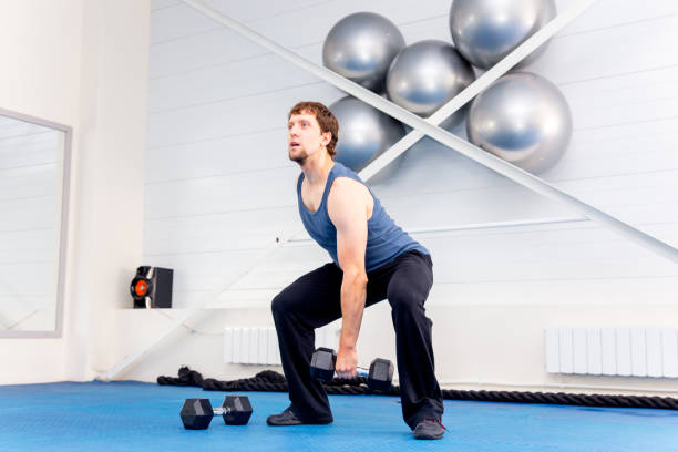 istock Young muscular man doing gym exercises in a gym 1045278722