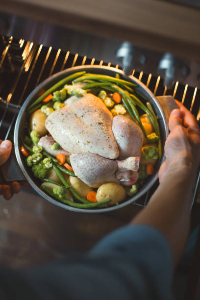 istock Cook putting raw chicken to the oven 1045279140