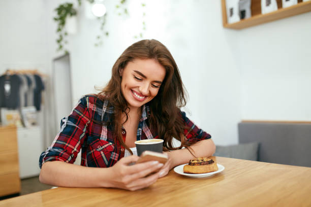 istock Happy Woman Using Phone In Cafe 1045279374