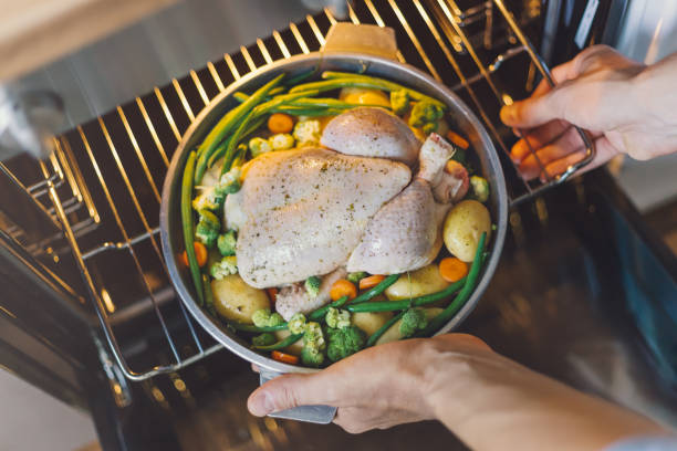 istock Cook putting raw chicken to the oven 1045279426
