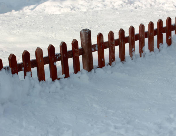 istock snow covered wood fence 1045279558
