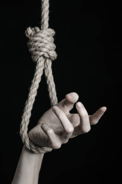 istock Suicide and depression topic: human hand hanging on rope loop on a black background 1045282146