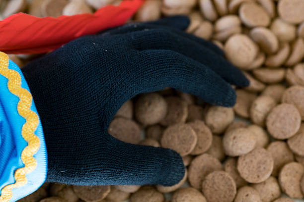 gant noir avec des biscuits appelée kruidnoten, pour événement néerlandais sinterklaas - black piet photos et images de collection