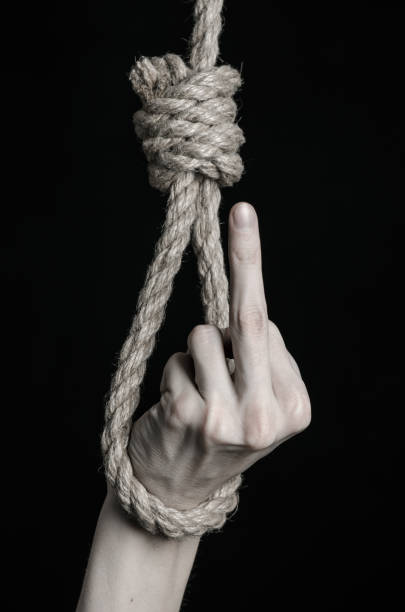 istock Suicide and depression topic: human hand hanging on rope loop on a black background 1045283708