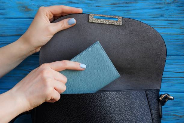 istock woman hand is laying a gray notebook in a black leather bag 1045283844