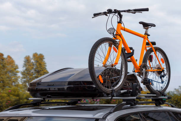 transport de vélos sur le toit de la voiture. concept : un voyage en voiture avec un vélo - bicycle rack photos et images de collection