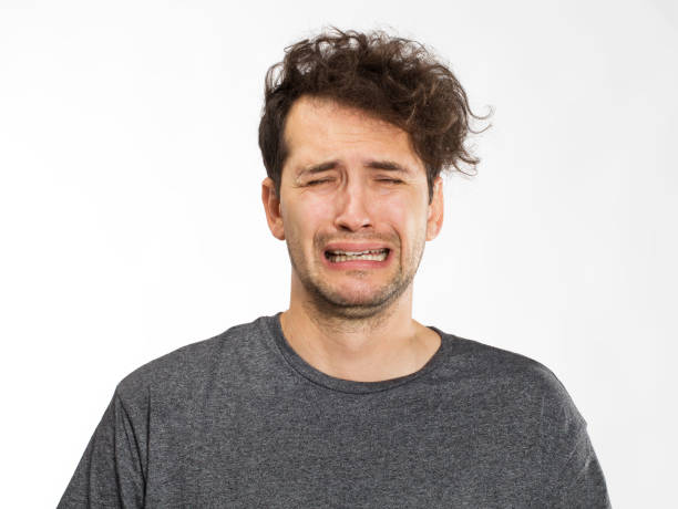 gefrustreerd en ongerust jongeman portret in grijs t-shirt - huilen stockfoto's en -beelden