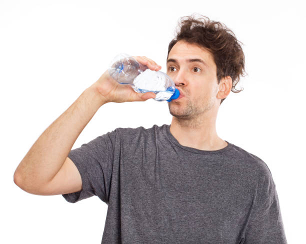 istock Portrait of cheerful young man drinking water 1045297584