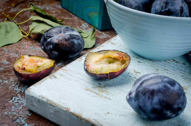 istock Fresh picked plums in pottery bowl  and plums pastille on dark background 1045303180
