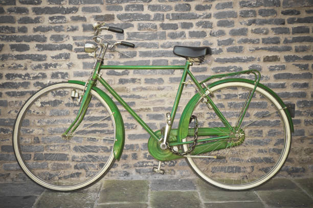 istock Old green bicycle parked against a brick wall 1045306482