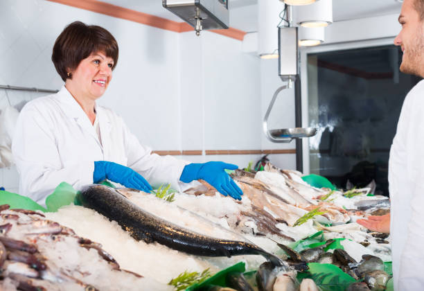 istock Glad woman selling chilled fish in store 1045307294