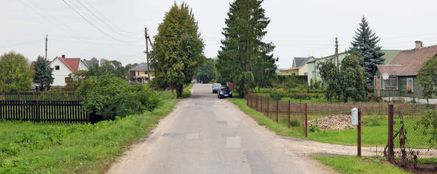 istock Broken asphalt road to a poor Lithuanian village rural landscape. Panoramic collage 1045313292
