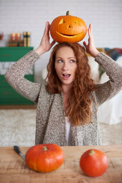 istock Playful girl with halloween pumpkin 1045317074