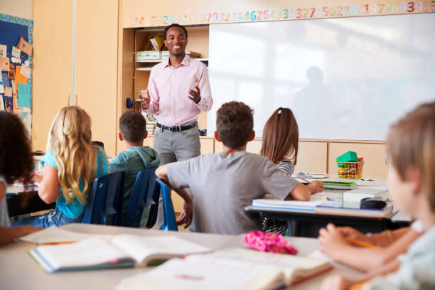 istock Kids listening to teacher in an elementary school class 1045321900