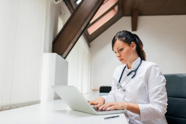 istock Serious female doctor working on laptop. 1045322108