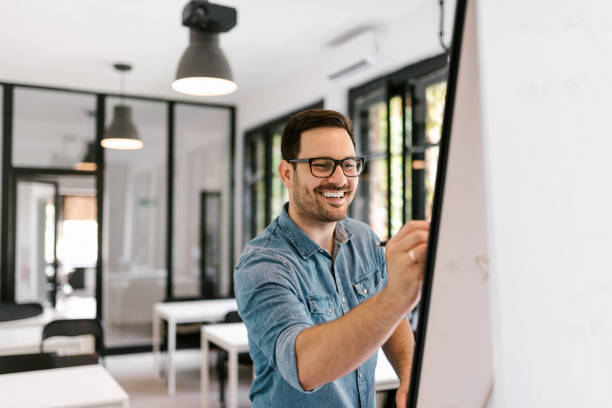 istock Smiling man writting on whiteboard. 1045322208