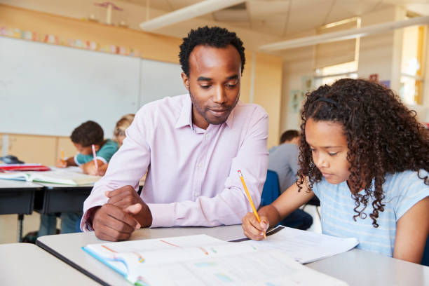 istock Elementary school teacher working with schoolgirl, close up 1045322218