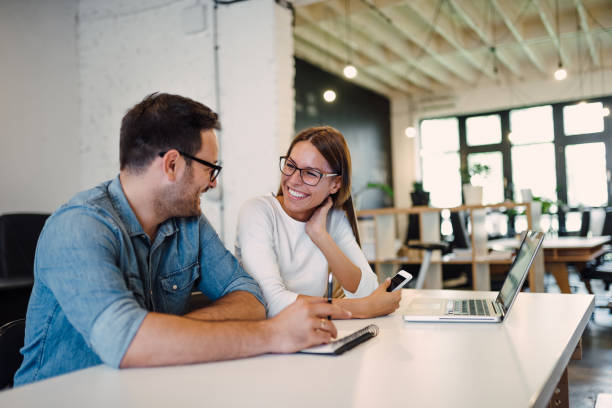 istock Two smiling colleagues talking in modern open space office. 1045322316