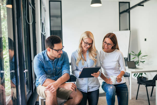 istock Three young people working together in bright office. 1045322324