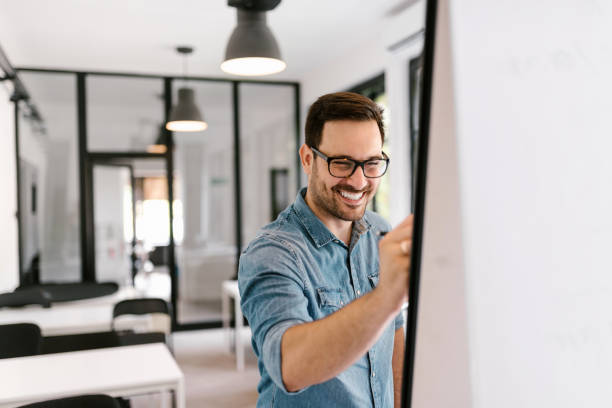 istock Handsome young man writing on the flipchart. 1045322338