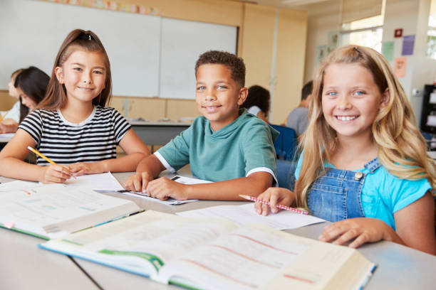 istock Elementary school kids in class smiling to camera, close up 1045322552
