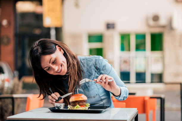 istock Young woman enjoying delicious burger. 1045322564