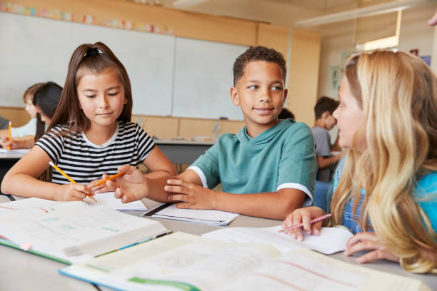 istock Elementary school kids in class working together at a desk 1045322680