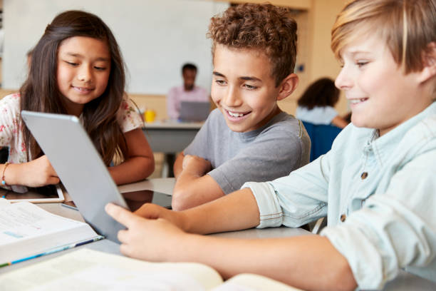 ragazzi delle scuole elementari che usano il tablet in classe scolastica - multi ethnic group concentration student asian ethnicity foto e immagini stock