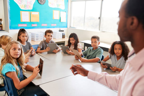 istock School kids learn to use tablets in elementary school lesson 1045327576