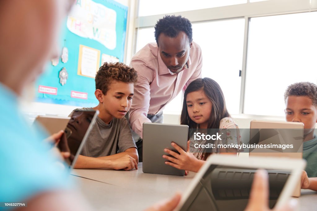 先生クラスのコンピューターを使用して学校の子供たちの間で - テクノロジーのロイヤリティフリーストックフォト