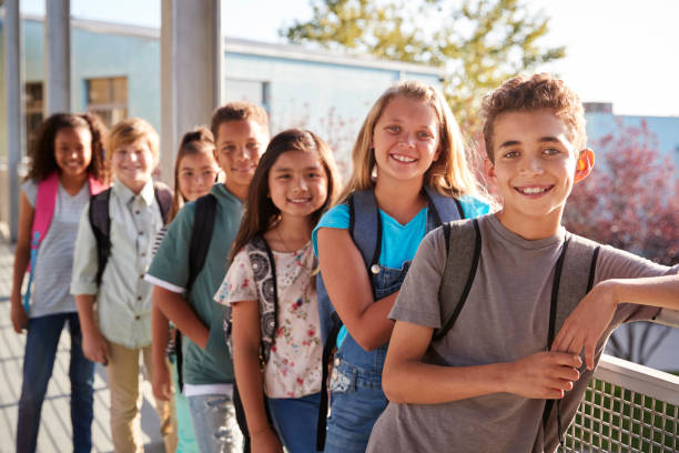 istock Elementary school kids with backpacks smiling to the camera 1045328864