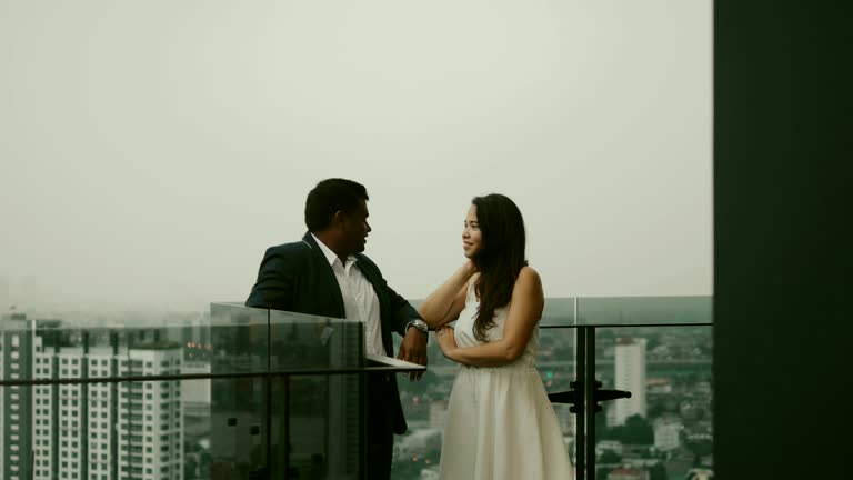 Young Asian couple on the balcony with city scape view- Stock video