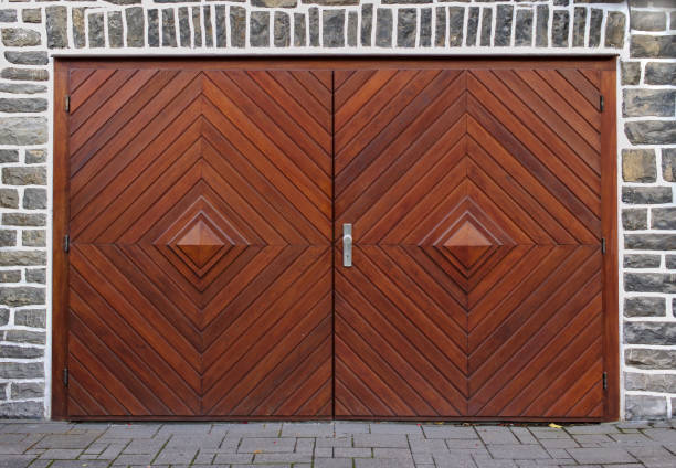 old gray stone wall with double-leaved wooden herringbone garage door - door symmetry wood closed imagens e fotografias de stock