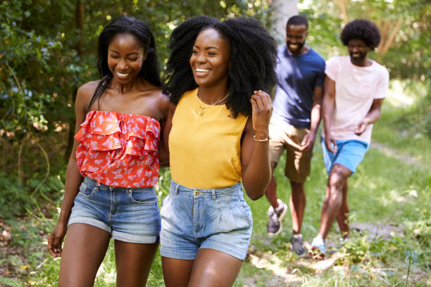 istock Two black adult couples talking during a walk in a forest 1045343004