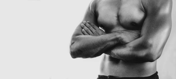 istock Unrecognizable Strong bald bodybuilder with six pack  personal fitness trainer flexing his muscles 1045343036
