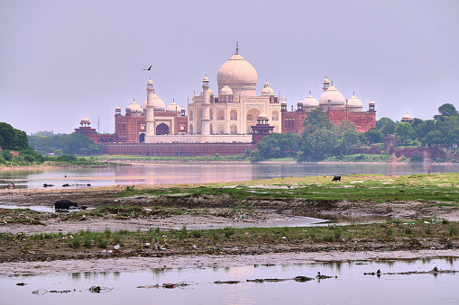 Beautiful morning view of Taj Mahal Palace with Jamuna river in the foreground.
