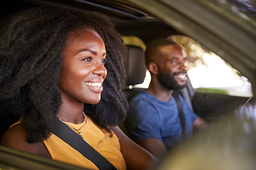 Young black couple smiling in a car during a road trip