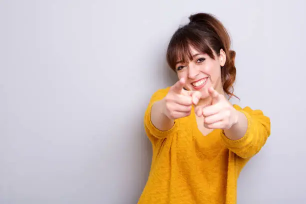 Photo of cheerful young woman pointing finger at you