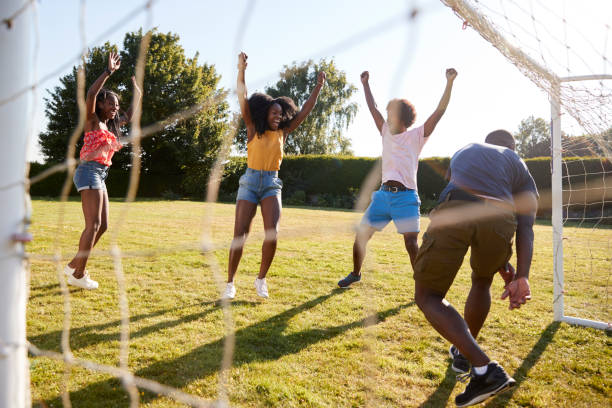 istock Three adults celebrate scoring goal against their friend 1045347298