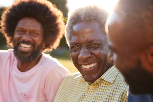 senior black man laughing with his two adult sons, close up - senior adult african descent men black imagens e fotografias de stock