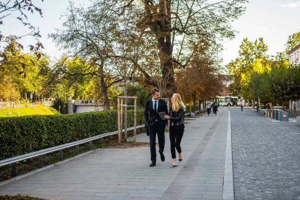 istock Businesspeople using a digital tablet and walking in the park 1045348012