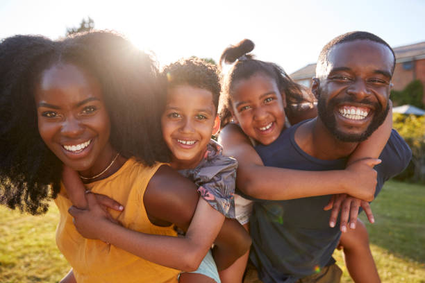 Black parents piggybacking their young kids, close up Black parents piggybacking their young kids, close up happy sibling day stock pictures, royalty-free photos & images