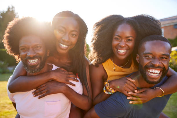 istock Two black couples, men piggybacking their partners, close up 1045348064