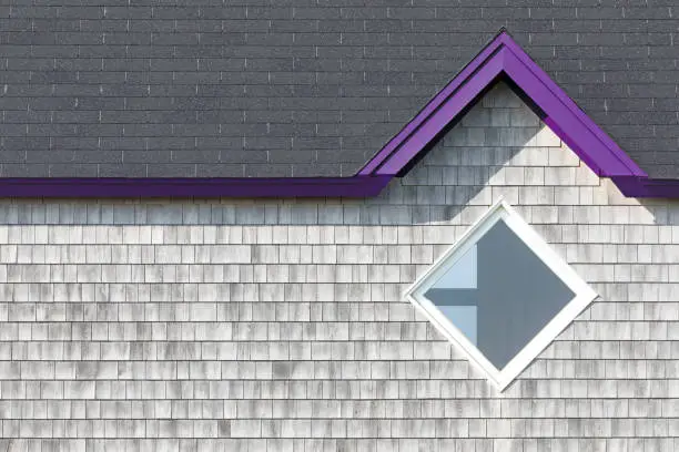 Photo of Detail of the facade of the typical wooden houses of Iles de la Madeleine, or the Magdalen Islands, in Canada. Minimalistic style in with purple accent and space for text.