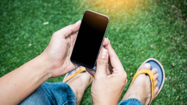 istock Man holding smart phone nature background 1045359542