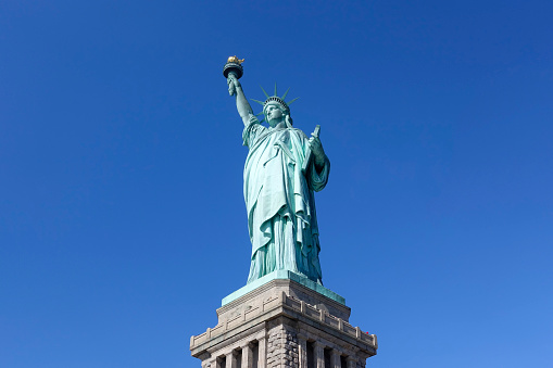 Statue of liberty in blue bright clear sky day tourist attraction most famous place of NYC USA