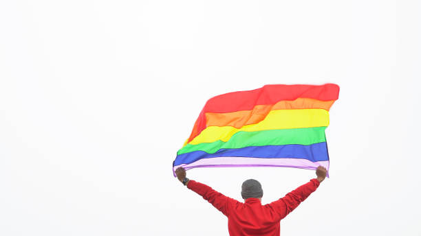 istock Man raised lgbtiq rainbow flag white background 1045360762